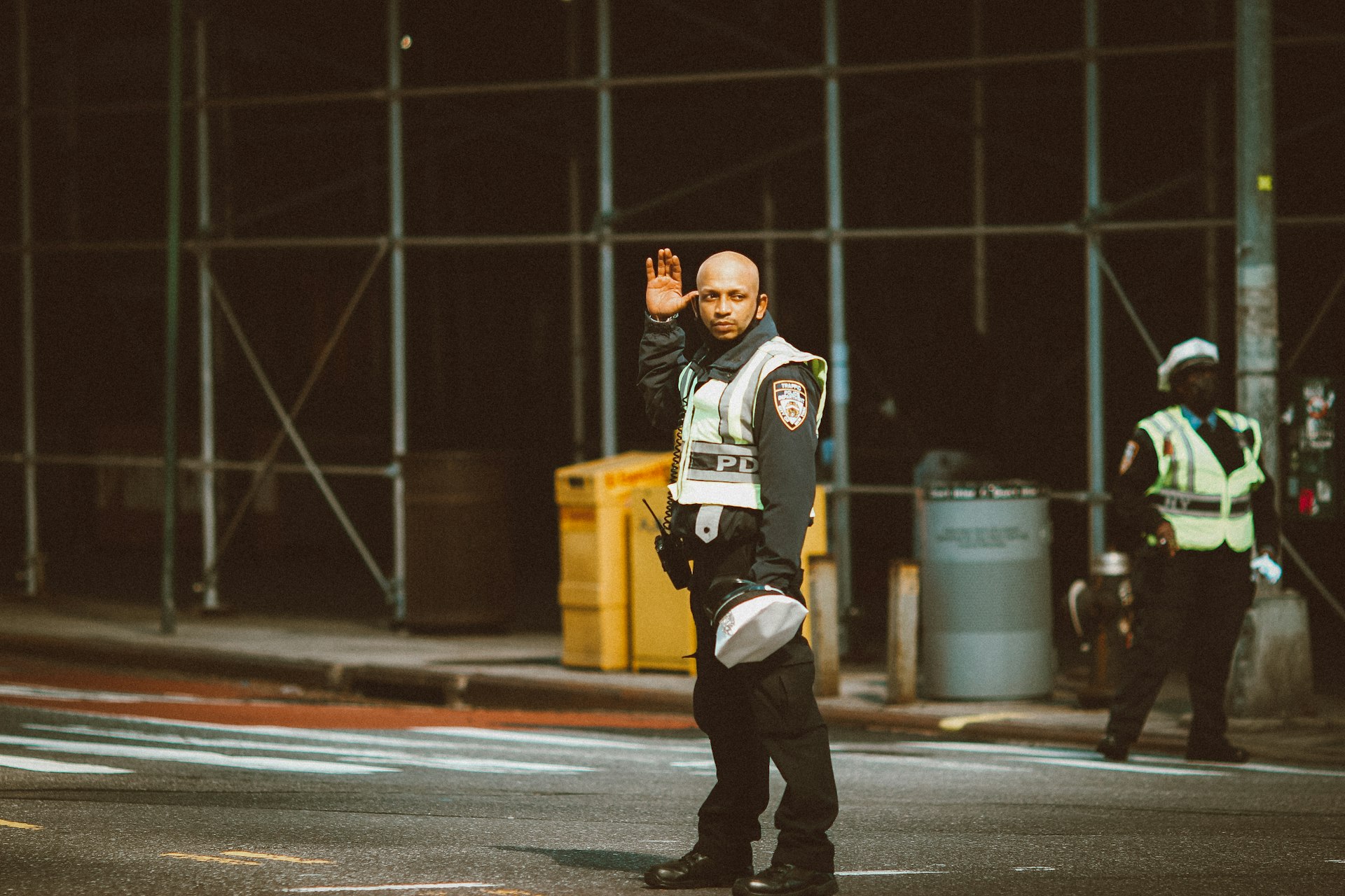 man in black and white long sleeve shirt and black pants standing on road during daytime